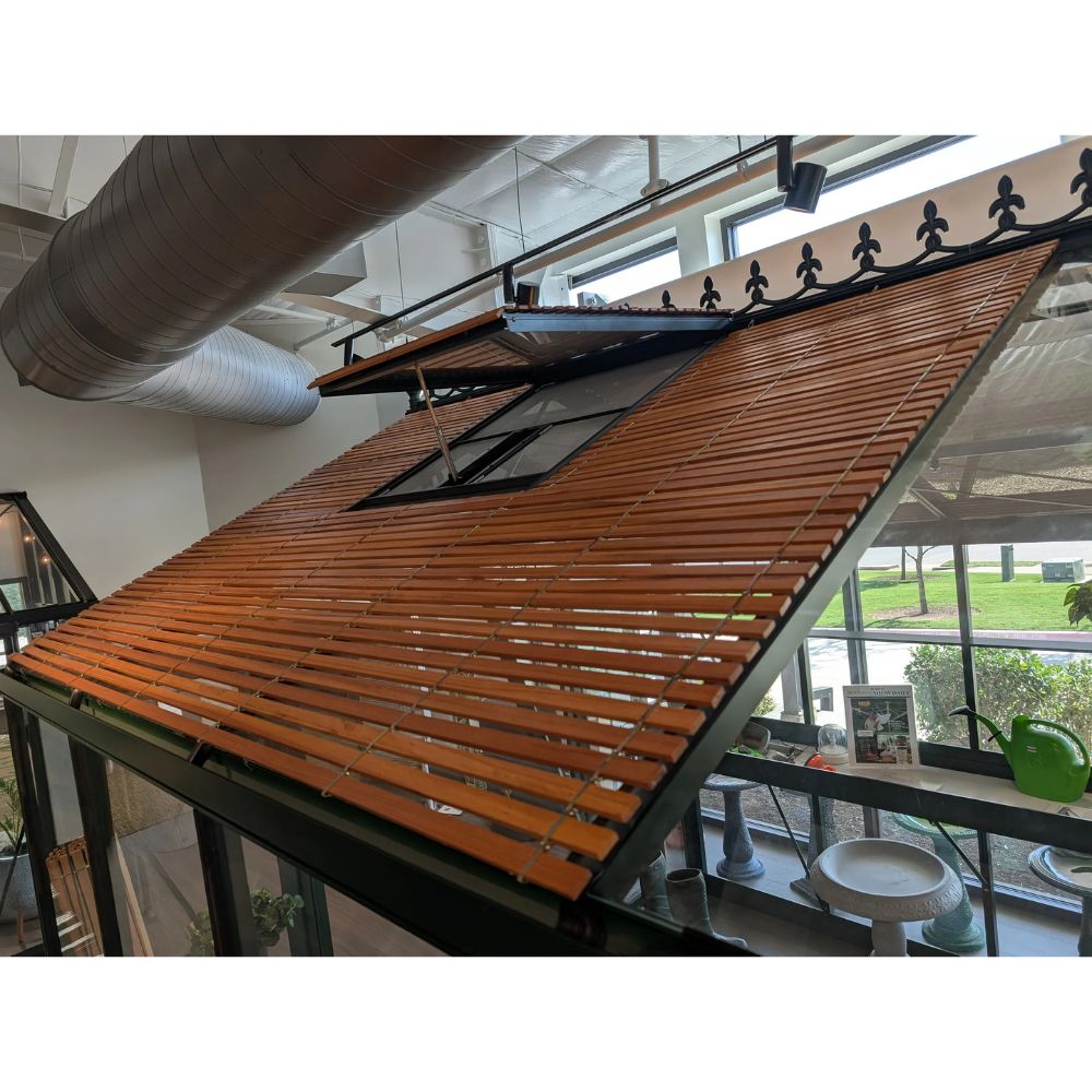 Wooden slatted roof structure in an indoor setting with large windows
